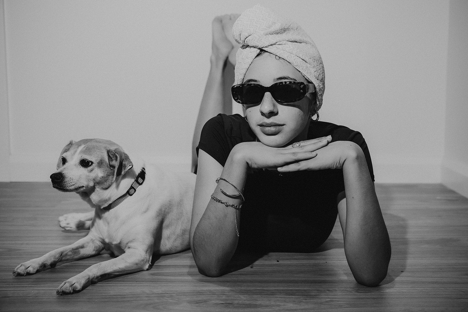 Model wearing an extra long hair towel, lying on the floor beside a small dog in a relaxed morning lifestyle setting